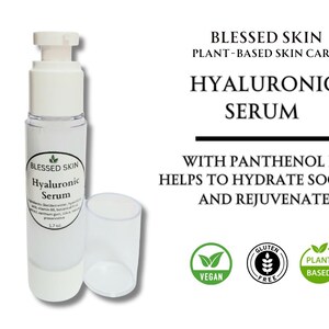 May include: A clear plastic pump bottle of Blessed Skin Hyaluronic Serum with a white cap. The label lists ingredients and 1.7 oz volume. Text reads: Blessed Skin Plant-Based Skin Care, Hyaluronic Serum, with Panthenol B5, helps to hydrate, soothe and rejuvenate. Includes Vegan, Gluten Free, and Plant Based icons.