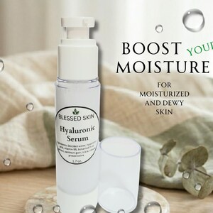 May include: A clear plastic pump bottle of Blessed Skin Hyaluronic Serum with a white cap. The label lists ingredients and 1.7 oz volume. Text on the right reads: BOOST YOUR MOISTURE FOR MOISTURIZED AND DEWY SKIN. The bottle stands next to its cap.