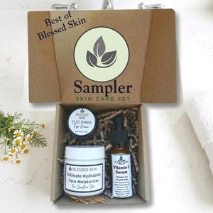 May include: A skincare sampler set in a brown box with the text "Best of Blessed Skin" and "Sampler SKIN CARE SET". The box contains a jar of eye cream, a jar of face moisturizer, and a bottle of Vitamin C serum.