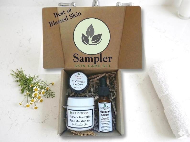 May include: A skincare sampler set in a brown box with the text "Best of Blessed Skin" and "Sampler SKIN CARE SET". The box contains a jar of eye cream, a jar of face moisturizer, and a bottle of Vitamin C serum.
