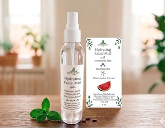 May include: A clear glass spray bottle and a product information card for Hydrating Facial Mist. The bottle has a white cap and a label with the product name, ingredients, and brand name. The card lists ingredients and a watermelon graphic. A sprig of mint is in front.