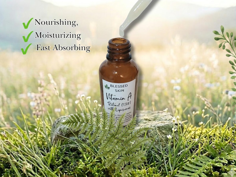May include: An opened bottle of Vitamin A Retinol showing the dropper and product in a grassy field.  The product benefits are that it's nourishing, moisturizing, and absorbs quickly.