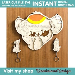 Può includere: Un file SVG di taglio laser con il design di una testa di leone con le parole "Hakuna Matata" e due personaggi di leone. Il design è perfetto per creare un'appendice murale in legno o un portachiavi.