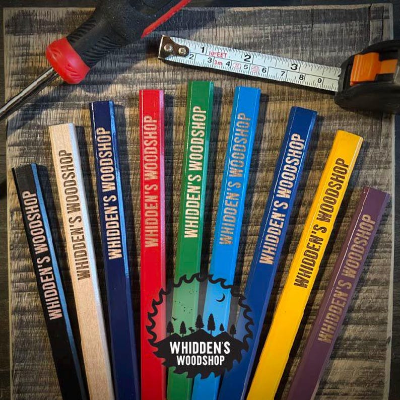 Pu&ograve; includere: Nove matite da carpentiere in legno con il testo "Whidden's Woodshop" stampato su ciascuna. Le matite sono di diversi colori: nero, legno naturale, blu, rosso, verde, blu, giallo, viola e marrone.