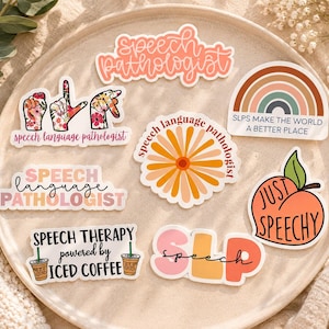May include: A collection of eight vinyl stickers featuring speech pathology themes. Designs include floral hand signs, a rainbow with text, a daisy, a peach with the text Just Speechy, and phrases like Speech Therapy powered by Iced Coffee and SLP.