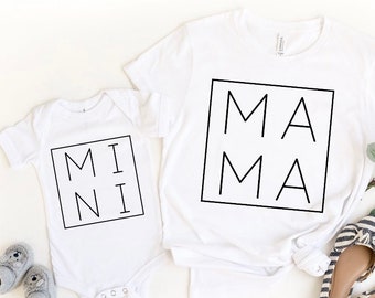 May include: White t-shirts with black text. The larger shirt says "MAMA" in a box. The smaller shirt says "MINI" in a box.