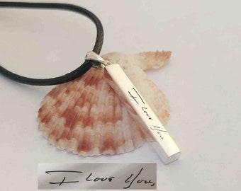 May include: A silver necklace with a black cord and a bar pendant engraved with the words "I love you".