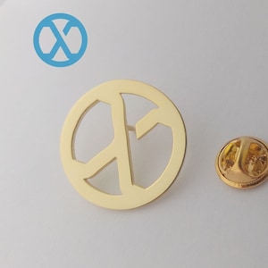 Puede incluir: Pin de oro con forma de signo de paz con un cierre de seguridad de oro.