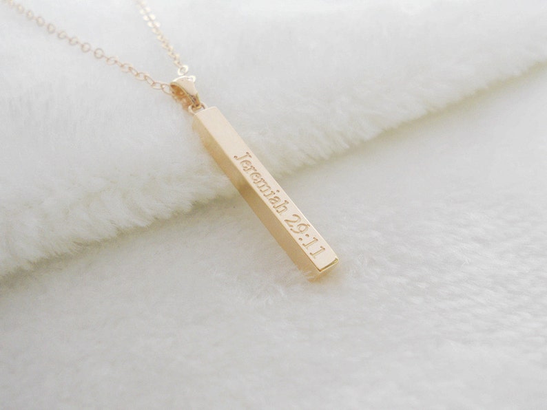 Puede incluir: Collar de barra de oro con una cadena delicada y un colgante grabado con el texto "Jerem&iacute;as 29:11".