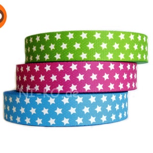 Könnte beinhalten: Drei Rollen weißer Sternmusterband in Grün, Pink und Blau.