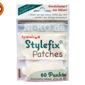 Peut inclure: Un paquet de 60 patchs adhésifs en tissu double face blancs appelés "Stylefix Patches" de "farbenmix.de". L'emballage indique "Revolutioniert das Nähen!" (Révolutionne la couture !) et "Gut fixiert ist schneller genäht!" (Bien fixé, c'est cousu plus vite !).
