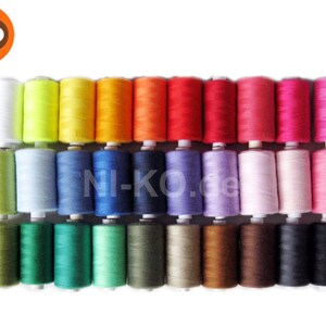 Könnte beinhalten: Ein Set mit 30 Garnrollen in verschiedenen Farben, darunter Weiß, Gelb, Orange, Rot, Rosa, Blau, Grün, Braun und Schwarz. Die Rollen sind in drei Reihen zu je zehn angeordnet.
