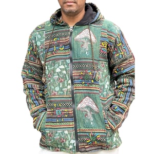 May include: Green patchwork zip-up hoodie with a black hood and lining. The jacket features a mushroom design and various patterns in shades of green, brown, and blue. It has a full-length zip and two front pockets.