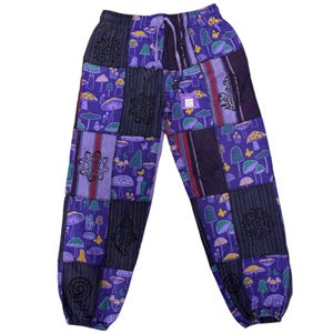 Puede incluir: Pantalones morados de patchwork con cintura con cordón. Los pantalones presentan una variedad de cuadrados estampados con diseños de setas y mariposas en tonos morados, verdes y amarillos. Los pantalones tienen un corte holgado y están hechos de tela suave.