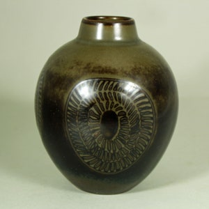 May include: A small, round, green ceramic vase with a brown, swirling design.