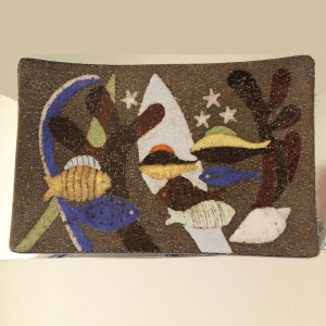 May include: Rectangular decorative tray with an underwater scene. The tray features a dark brown background with colorful fish, coral, and abstract shapes in shades of blue, yellow, white, and brown. The tray is likely made of glass or ceramic.