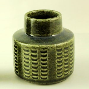 Pode incluir: Um vaso de cerâmica verde com um padrão texturizado. O vaso tem uma base larga e um pescoço estreito.
