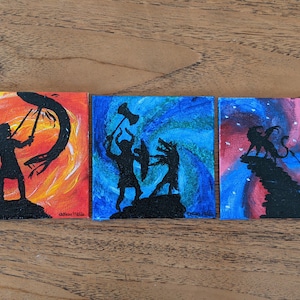 May include: Three small square paintings depicting silhouetted figures in action. The first shows a warrior with a spear and sword against an orange and yellow background. The second shows figures with a hammer and shield against a blue background. The third shows figures against a blue and red background.