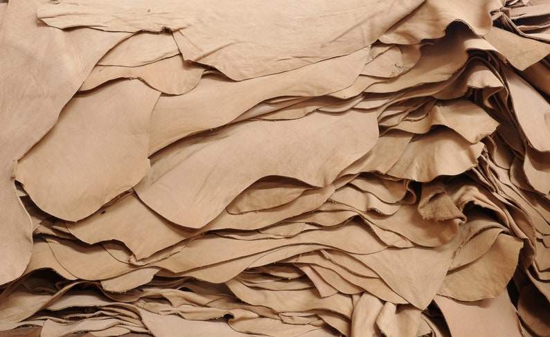 Puede incluir: Una pila de pieles de cuero marr&oacute;n claro, mostrando la textura natural y la veta del material.