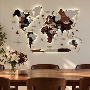 May include: A multi-layered wooden world map wall art piece featuring various shades of brown, black, and white. The map includes labelled continents, countries, and oceans, accented by integrated LED backlighting and decorative wooden aeroplane icons.