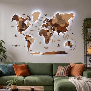 Peut inclure: Une grande carte du monde murale en bois multicouche, composée de différentes nuances de brun et éclairée par un rétroéclairage LED blanc vif. La carte comprend des continents, des îles découpés et de petites icônes décoratives d'avions et de bateaux.