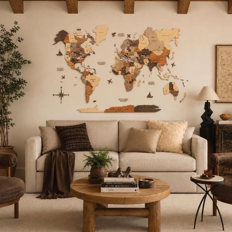 May include: A large, multi-piece wooden world map wall art installation featuring various shades of brown and tan wood tones, mounted on a wall above a beige sofa. The map includes detailed continents, islands, and small decorative wooden icons.