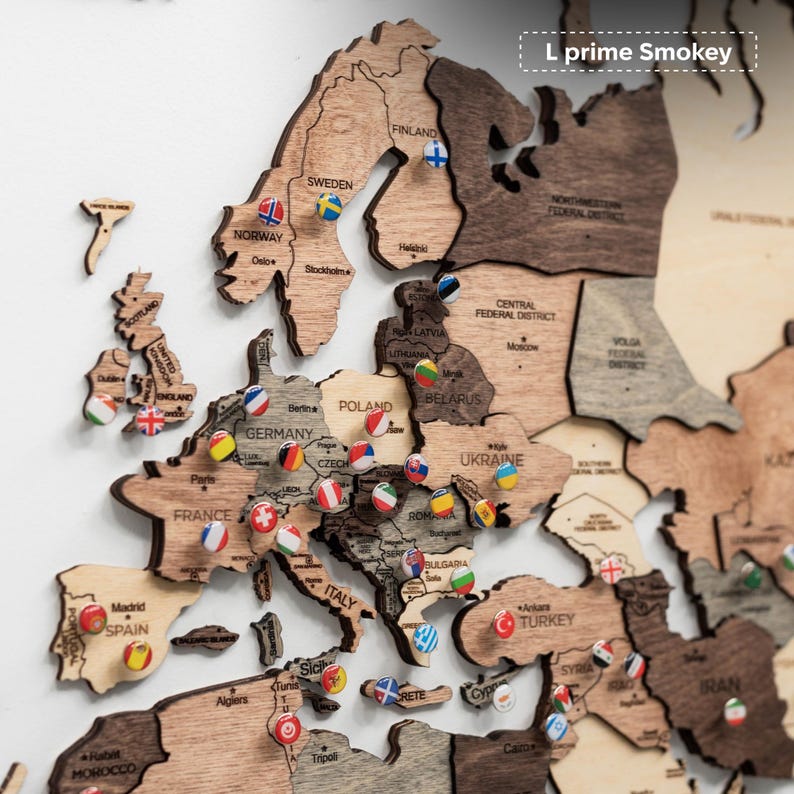Pu&ograve; includere: Una mappa in legno dell'Europa con i contorni dei paesi e spilli che segnano le localit&agrave;. La mappa &egrave; realizzata in varie tonalit&agrave; di legno marrone. Ogni spillo ha un disegno a bandiera, che rappresenta diversi paesi. Il testo "L prime Smokey" si trova in alto a destra.