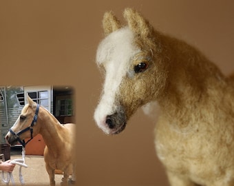 May include: A detailed felted horse figurine in shades of tan and cream. The horse has a white blaze and a realistic, handcrafted appearance. A smaller image of a real horse is in the background. The figurine is a charming decorative item.