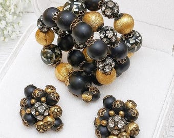 Conjunto vintage de pulsera y pendientes de clip con pedrería HOBE, negro y dorado.