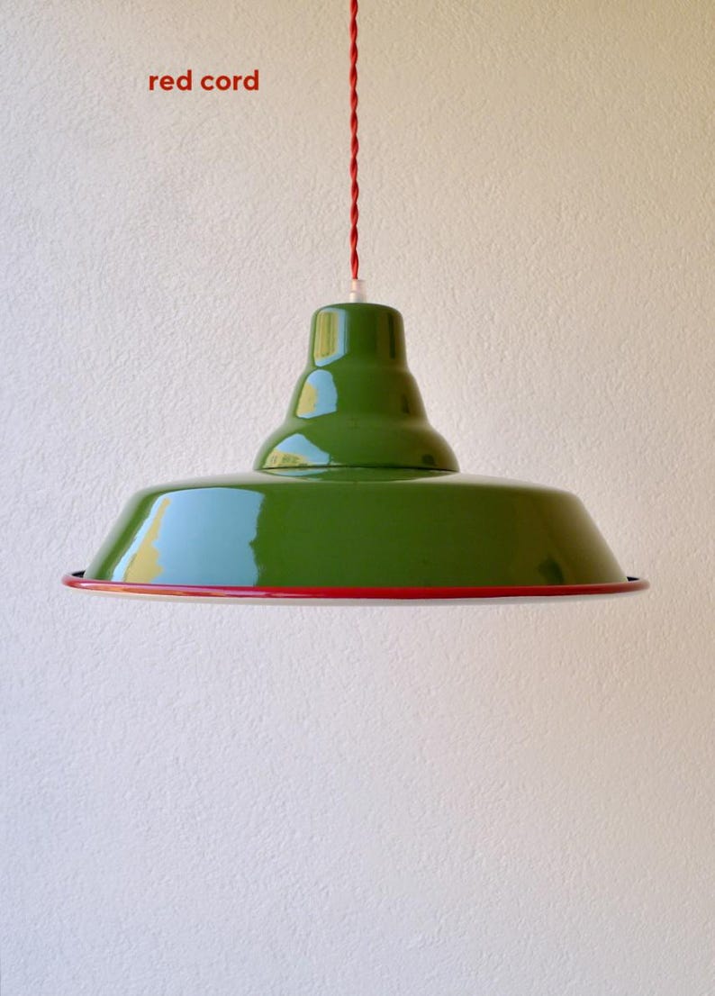 May include: A glossy green pendant light fixture with a wide, tiered dome shade and a thin red rim. The light hangs from a twisted red cord. The text "red cord" is visible in the upper left corner of the image, indicating the cord color.
