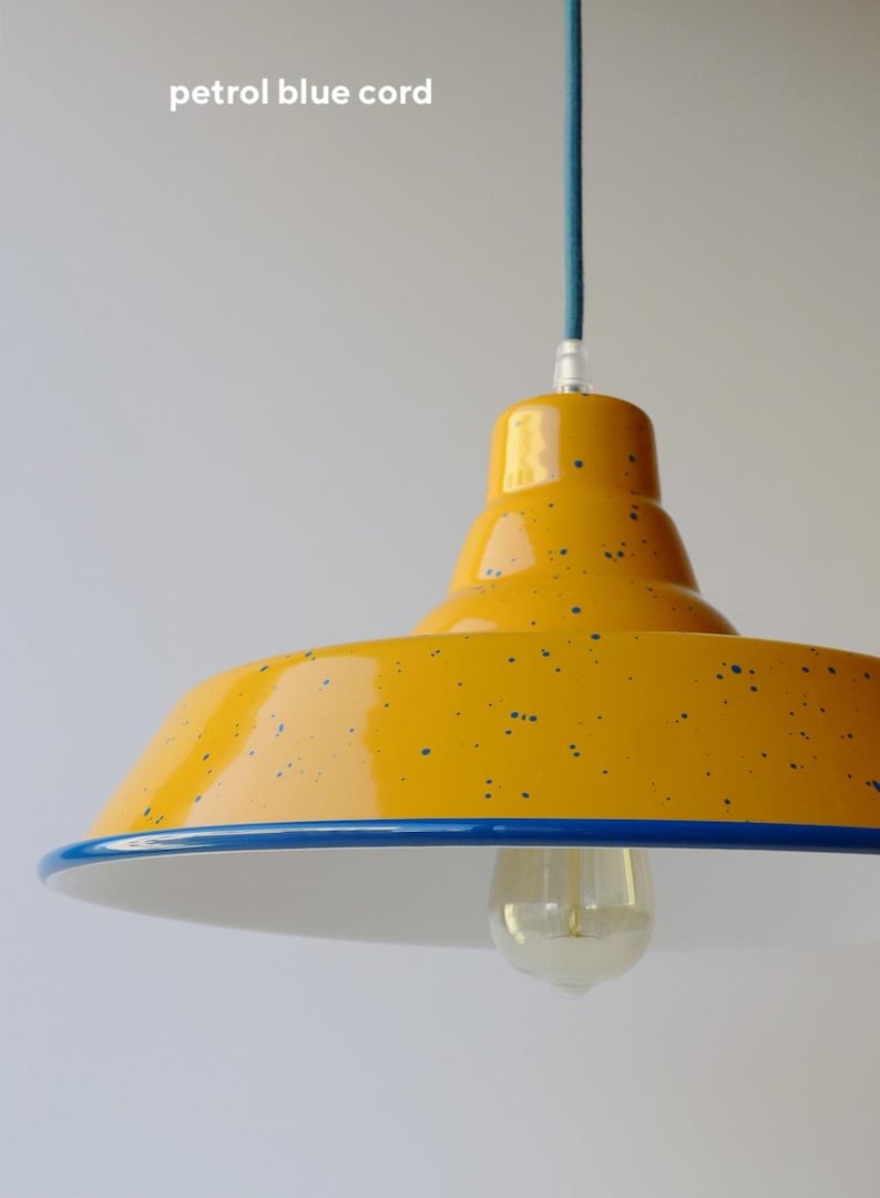May include: A yellow pendant light with a glossy finish and blue speckles, featuring a blue rim and a clear light bulb. The fixture is suspended by a petrol blue cord. The text "petrol blue cord" is visible in the upper left corner of the image.