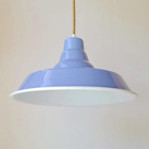 May include: A light blue pendant light fixture with a glossy finish and a wide, flared shade. The interior of the shade is white. The fixture is suspended from a natural tan jute cord. The text "jute cord" is visible in the upper left corner.