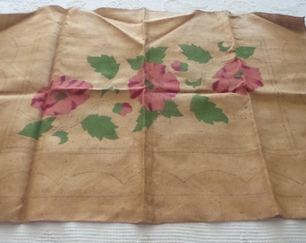 Könnte beinhalten: Beigefarbener Stoff mit einem Blumendesign aus rosa Blüten und grünen Blättern. Der Stoff hat eine rechteckige Form mit einem gewellten Rand und einem dekorativen Rand. Das Design ist handgemalt.