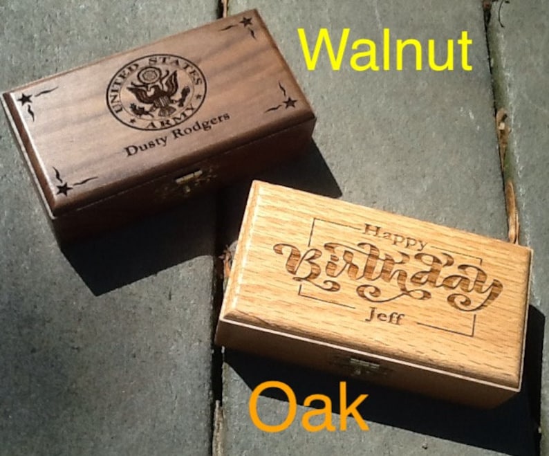 May include: Two wooden boxes with engraved designs. The top box is walnut and has a United States Army emblem with the text 'Dusty Rodgers' underneath. The bottom box is oak and has the text 'Happy Birthday Jeff' engraved on the top.