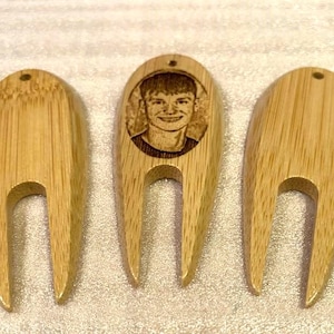 May include: Three wooden golf ball retrievers. One retriever has a laser engraved image of a person's face.