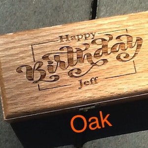 May include: A wooden box with the words 'Happy Birthday Jeff' engraved on the top. The box is made of oak wood and has a natural wood finish.