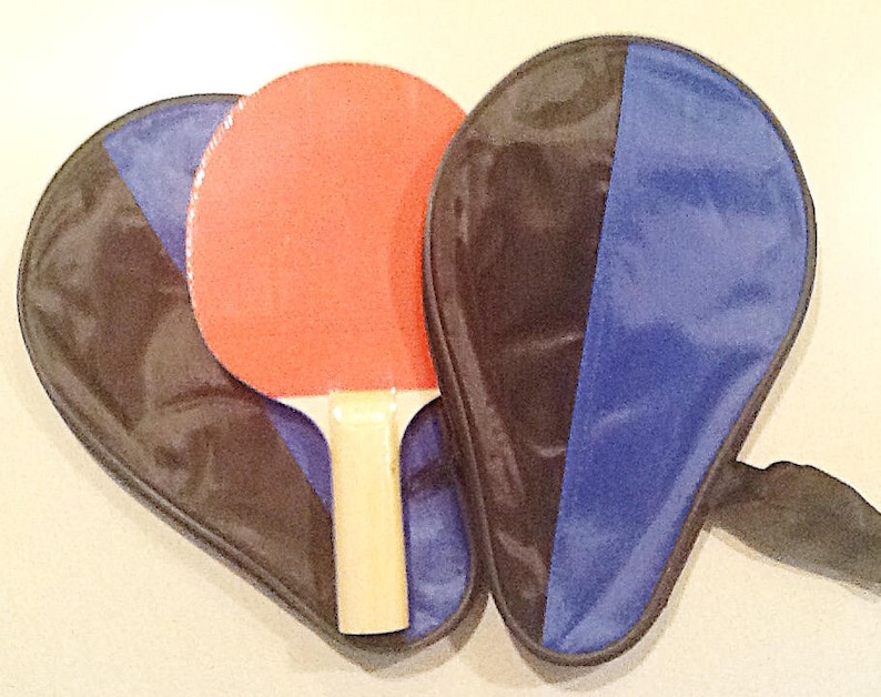 May include: A red and black ping pong paddle set with a black and blue carrying case.
