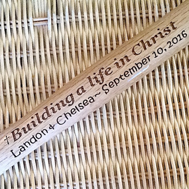 May include: A wooden baseball bat with the text "# Building a life in Christ Landon & Chelsea ~ September 10, 2016" engraved on it.