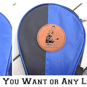 May include: A blue and black ping pong paddle bag with a brown leather patch that says "Matt Ping Pong Master".