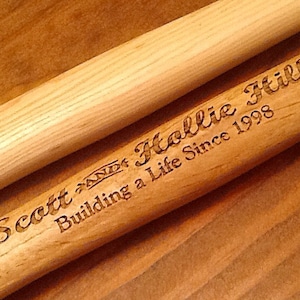 May include: Two wooden dowels with the text "Scott and Hollie Building a Life Since 1998" engraved on one of the dowels.