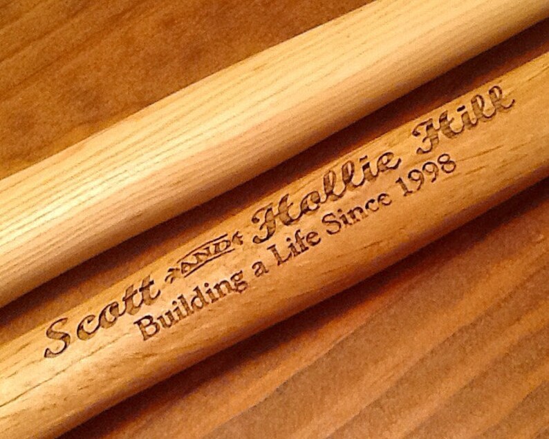 May include: Two wooden dowels with the text "Scott and Hollie Building a Life Since 1998" engraved on one of the dowels.