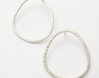 Handmade silver earrings with an oval shape and beautiful texture.