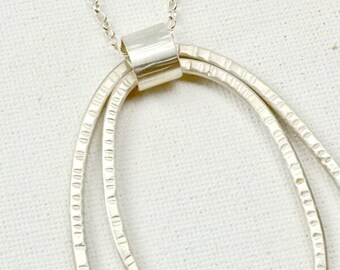 Long silver pendant. Two textured hoops, all handmade