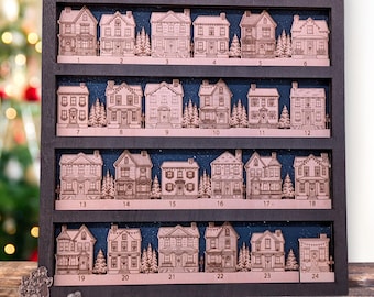 May include: Wooden advent calendar featuring 24 miniature house cutouts, each numbered and set against a starry blue background. The houses are arranged in a dark wooden frame, with small wooden figurines at the bottom. The Quiet Grove logo is visible.
