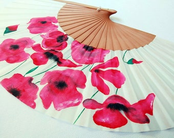 May include: A white folding fan with a wooden handle and a painted design of pink poppies.