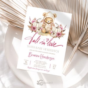 May include: Fall in love baby shower invitation with a watercolor illustration of a teddy bear wearing a hooded sweater and surrounded by pumpkins and flowers. The invitation includes the date, time, and location of the event. RSVP information is also included.