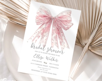 May include: A white bridal shower invitation featuring a large, pink bow with pearl accents. The invitation includes the text "bridal shower" in elegant script, along with event details such as the bride's name, date, time, and location. The Cardmint logo is visible.