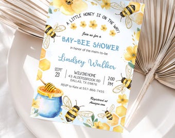 Può includere: Un invito a una festa di baby shower blu e giallo con tema delle api. L'invito dice "A little honey is on the way!" e "Join us for a Bay-Bee Shower". Include anche il nome "Lindsey Walker", la data "Sept 23", l'ora "2:00 PM" e la posizione "Wilkins Home, 43 Aldersbrook Rd, Dallas, TX 09876". Le informazioni RSVP sono "RSVP to Kate at 557-866-7455". L'invito dice anche "Registered at Amazon.com".