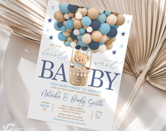 Könnte beinhalten: Eine Babyparty-Einladung in blau und braun. Die Einladung zeigt einen Teddybären in einem Heißluftballon aus blauen, braunen und weißen Ballons. Der Text auf der Einladung lautet "We can barely wait BABY" und enthält die Details zur Babyparty.