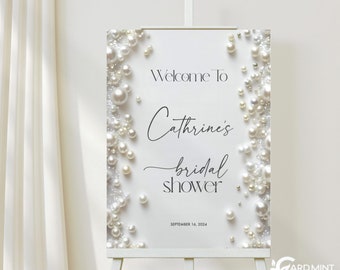 May include: White welcome sign with pearl accents, text reads "Welcome to Cathrine's bridal shower, September 16, 2024"